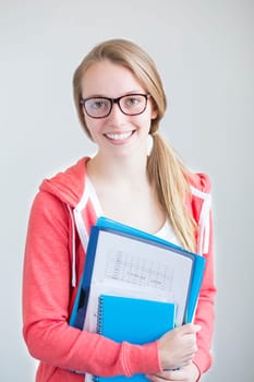 Portrait of an attractive young girl on a white background. She is holding folders and paper work.