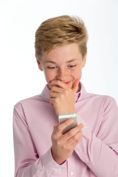 Teenage boy looking shocked at something on his smartphone. Close up shot against a white background.