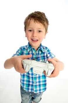 Young boy with a video game controller. He is standing against a white background.