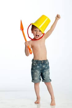 Little boy imitating a warrior with a bucket and spade