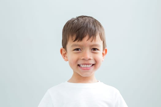 Landscape headshot of a young boy against a plain background