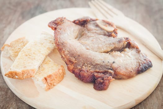 Pork steak on wooden plate, stock photo