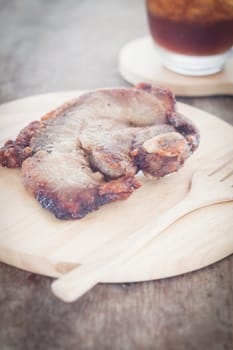 Pork steak on wooden plate, stock photo