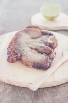 Pork steak on wooden plate, stock photo