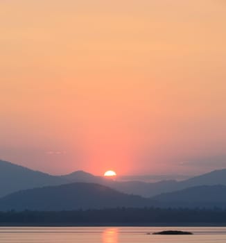 Beautiful sunset over the mountain with reflection on lake