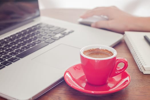 Red coffee cup with notepad and laptop, stock photo