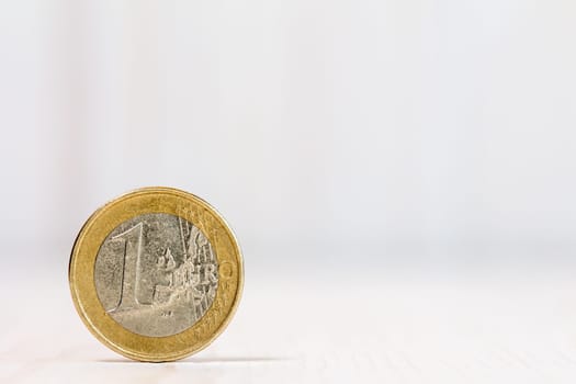 One euro coin on white wood  background. With copy-space for text