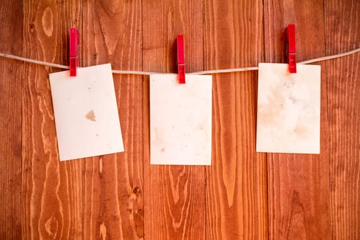 Photo  frames hanging on a rope over wooden background