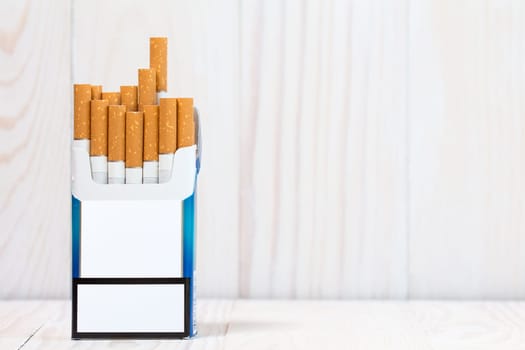 Pack of cigarettes on white wood  background. With copy-space for text