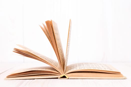 Open book on  white wood background. With place for text