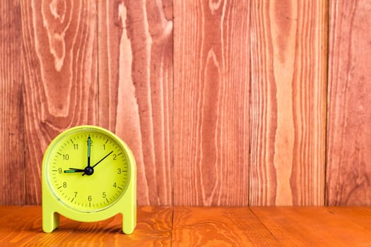 Alarm clock on the wood background. With copy-space for text