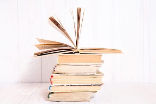 Old books stacked on white wooden  background, knowledge concept