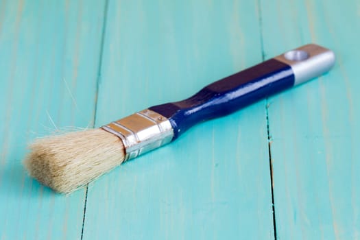 Paint brush on a wood surface, close up