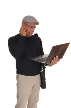 A middle ages Hispanic man standing isolated for white background.working on his laptop and wondering what hi is doing..