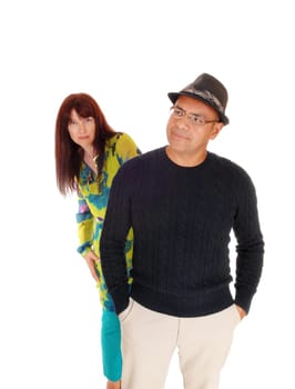 Middle age couple, a Hispanic man and Caucasian woman standing .behind each other, isolated for white background..