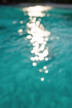 Blur green blue sea surface with reflecting sunlight evening in summer for background