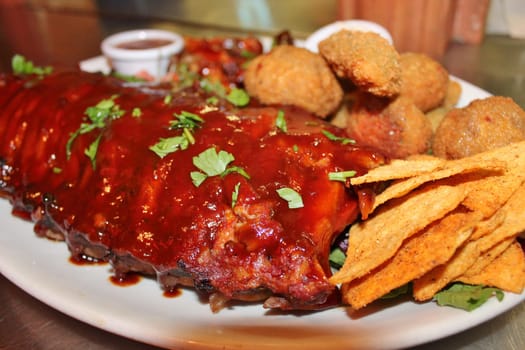 delicious bbq baby-back pork ribs with smokey bbq sauce platter of tortilla chips