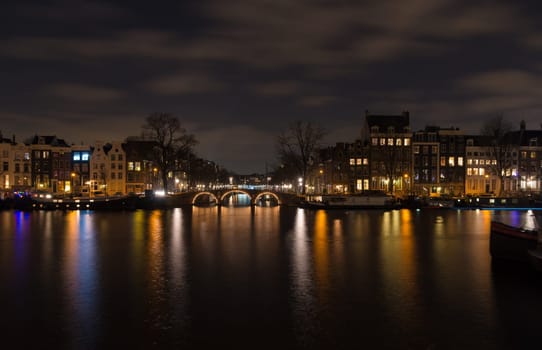 illuminated amsterdam canal and bridge at night