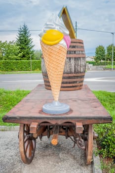 Farm cart with large plastic ice cream, and a wine barrel