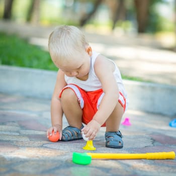 Baby boy playing toy golf outdoor