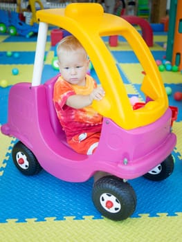 Cute kid boy playing with car