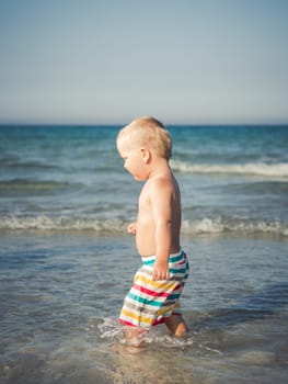 Cute baby plays in a sea