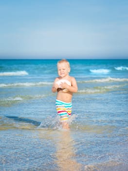 Cute baby plays in a sea