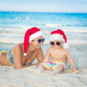 Baby and mother on the beach. Christmas concept