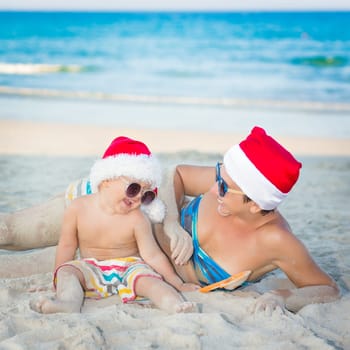 Baby and mother on the beach. Christmas concept