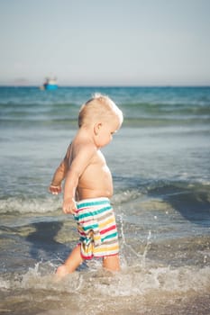 Cute baby plays in a sea