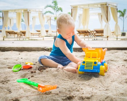 Cute baby is playing toy car