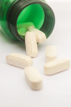 Vitamin spilling out of a bottle, Selective focus