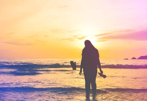 Silhouette vintage women in the sea with color of the sunset, Pathong beach, Phuket Thailand