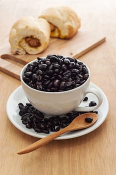 Fresh black coffee in a white cup of coffee with bread cut on wooden background