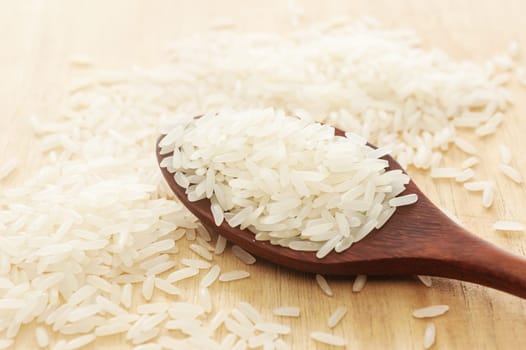 Rice,White rice in wooden spoon on a wood background