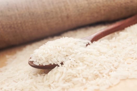 Rice, White rice in wooden spoon with hemp sack background, Selective focus