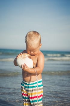 Cute baby plays in a sea