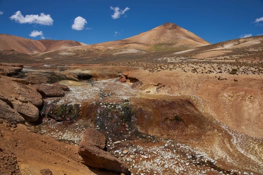 Dry riverbed running through the colourful desert landscape in Lauca National Park set in the altiplano of northern Chile