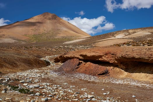 Dry riverbed running through the colourful desert landscape in Lauca National Park set in the altiplano of northern Chile