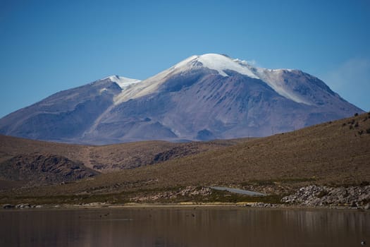 Snow capped Parinacota Volcano, 6,324m high, reflected in Lake Chungara in the Altiplano of northern Chile.
