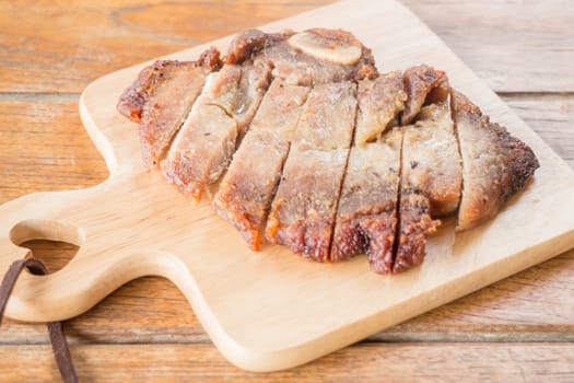Pork steak on wooden plate, stock photo