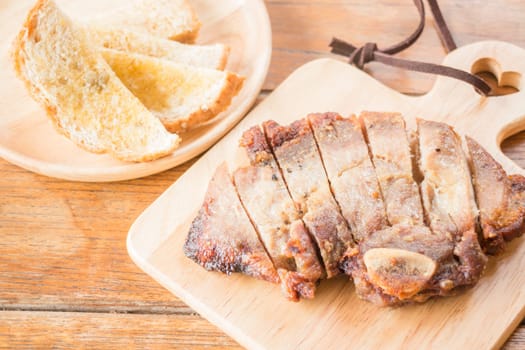 Pork steak on wooden plate, stock photo