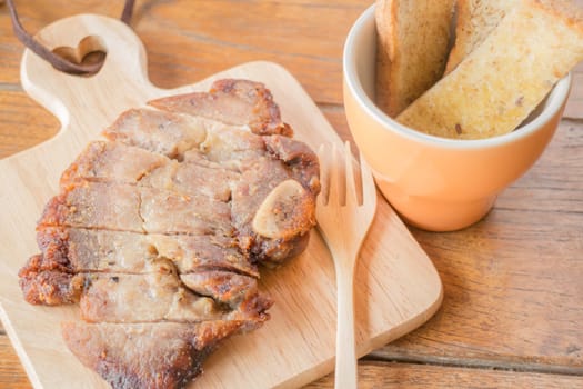 Pork steak on wooden plate, stock photo