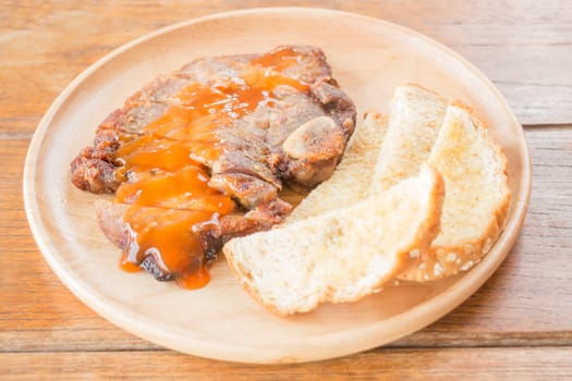 Pork steak on wooden plate, stock photo