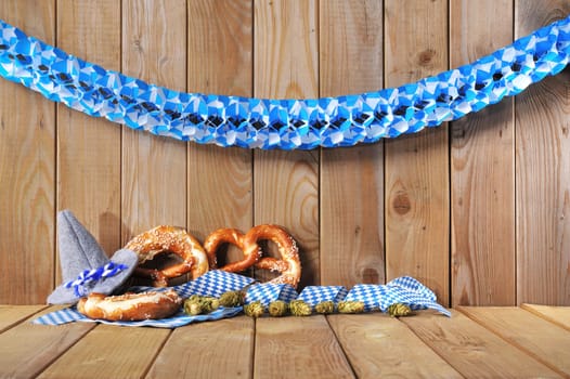original Bavarian Oktoberfest hat with lye brezen in front of old wooden boards