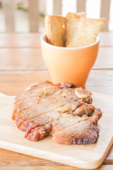 Pork steak on wooden plate, stock photo