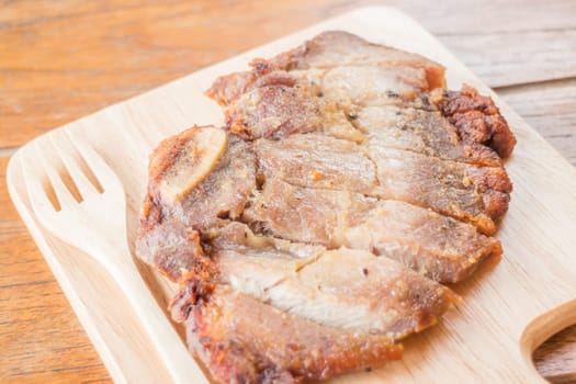Pork steak on wooden plate, stock photo
