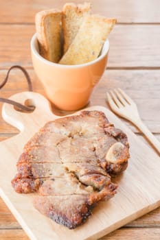 Pork steak on wooden plate, stock photo