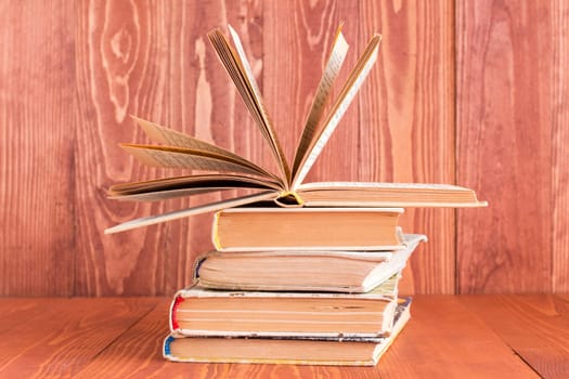 Books stacked on white wooden background. Education and knowledge concept
