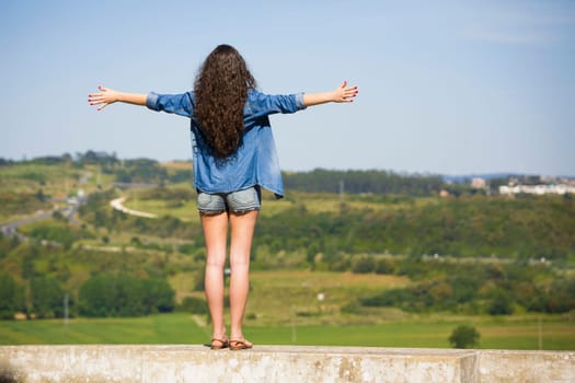 Beautiful young woman feeling the summer breeze and enjoying the vacations